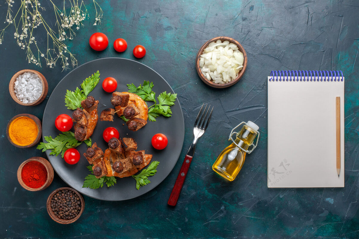 生的顶视图橄榄油和调味料炒肉片在深蓝色桌上蔬菜食品肉类健康餐肉橄榄顶部