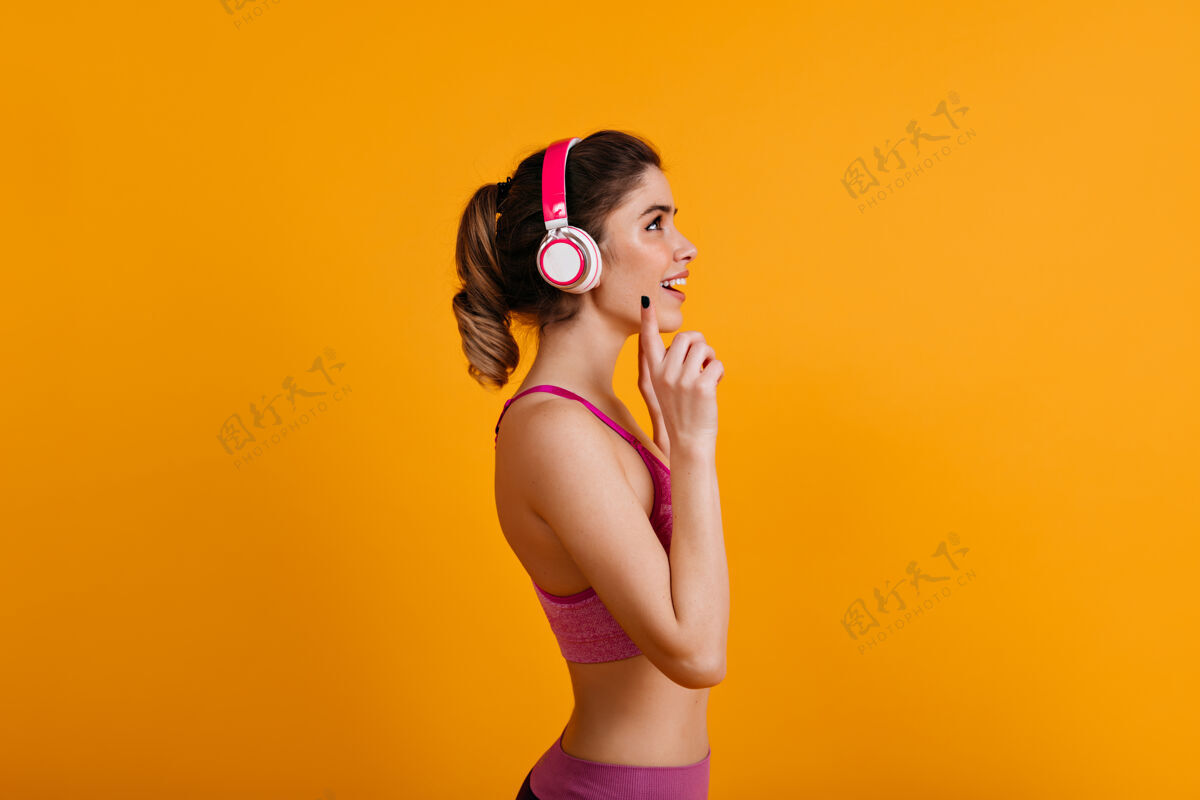 人可爱的黑发女人戴着耳机听音乐女士运动装女性