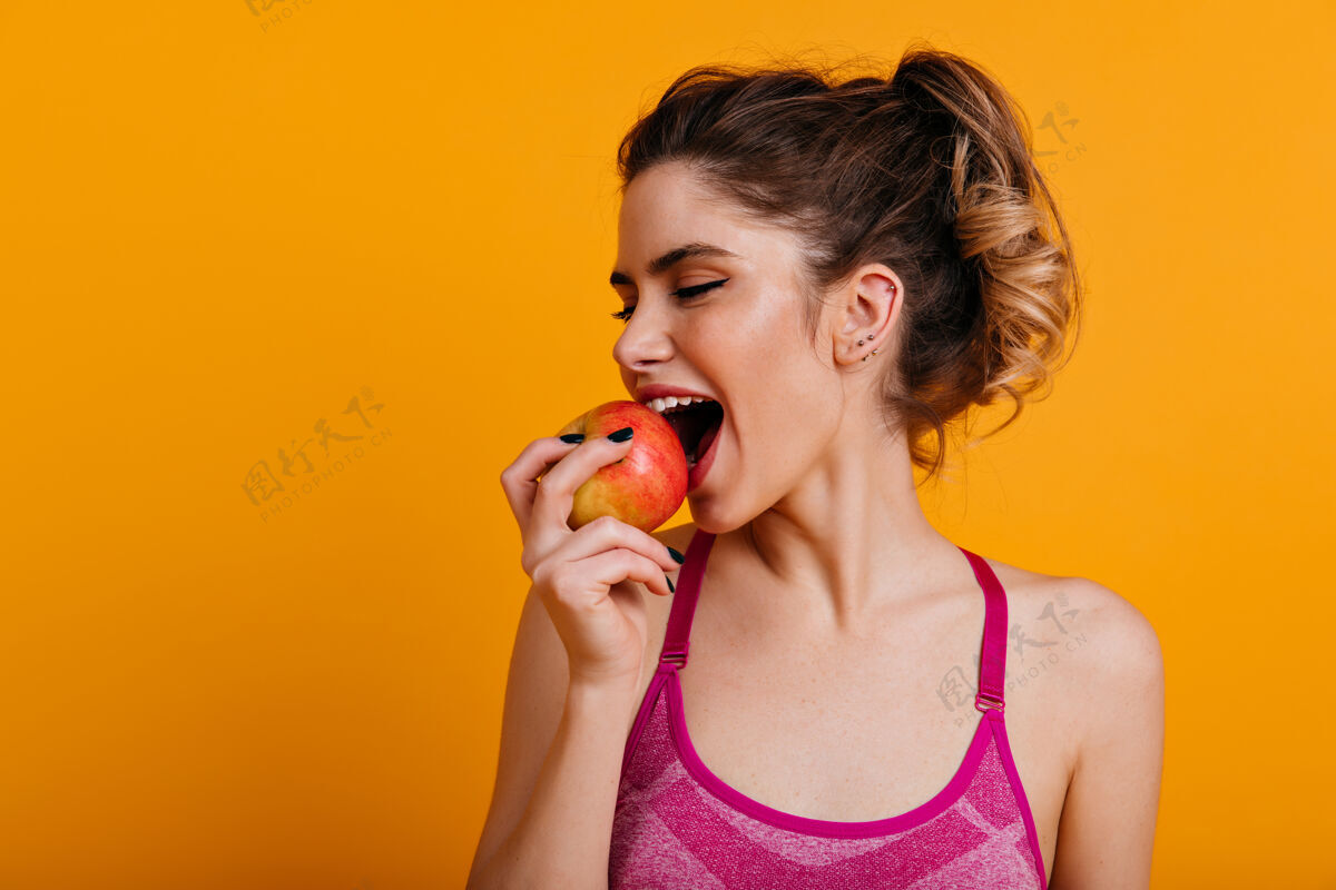 女孩极乐女人吃苹果的室内照片女人年轻快乐