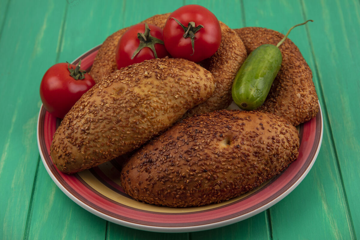 三明治一盘面包的顶视图 新鲜蔬菜如黄瓜和西红柿放在绿色的木制背景上景观西红柿黄瓜