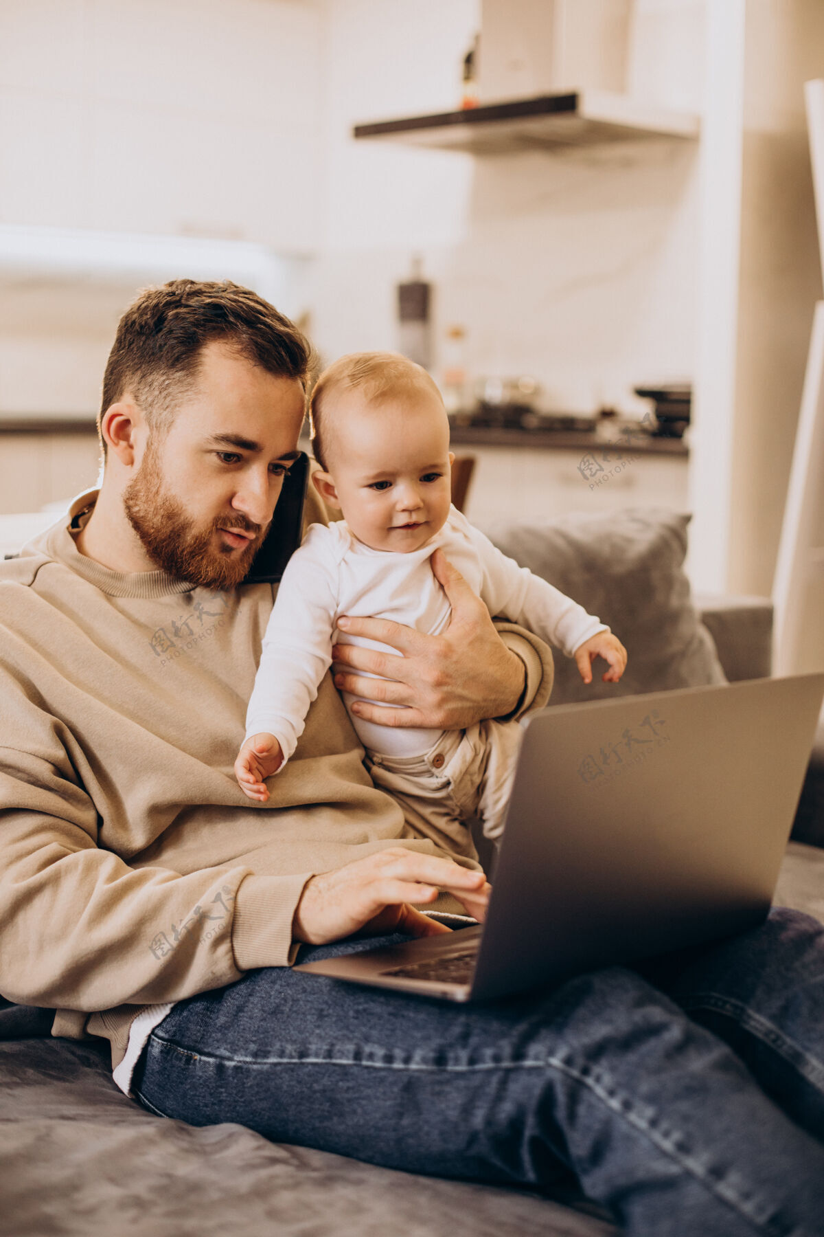 沙发年轻的父亲和他的女婴坐在一起 在家里用电脑笔记本电脑在家工作快乐
