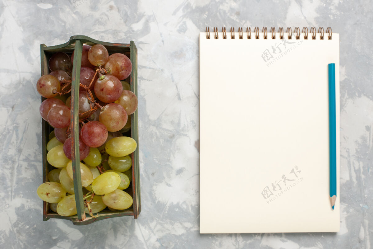 视图顶看新鲜葡萄 用记事本在白色的背景下 水果醇厚多汁新鲜有机背景新鲜