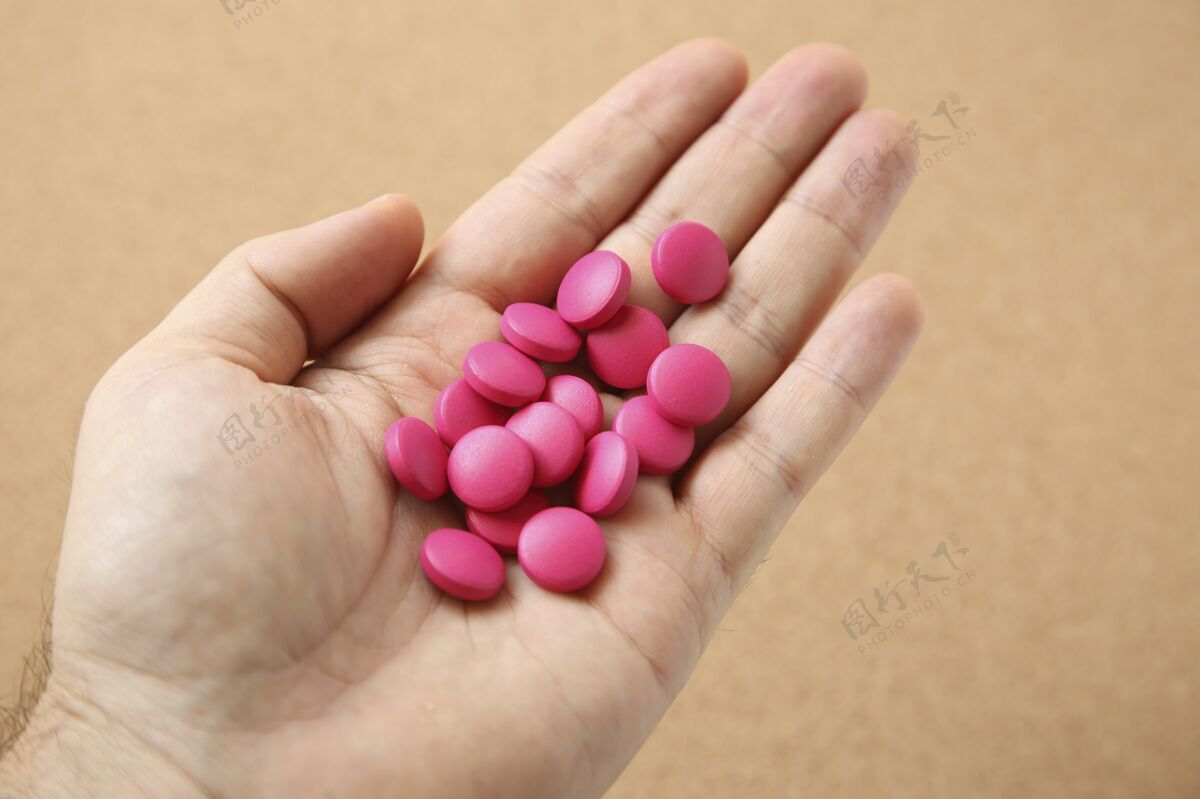 药房用一把粉红色的药片拍下一个人的手疾病成瘾粉色