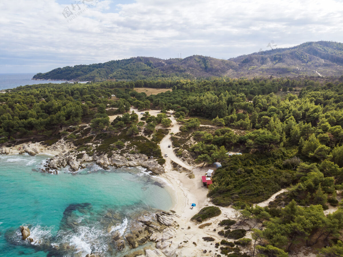 沙爱琴海沿岸有蓝色透明的海水 周围绿树成荫 岩石 灌木丛和树木 从无人机希腊俯瞰海湾海湾镁砂