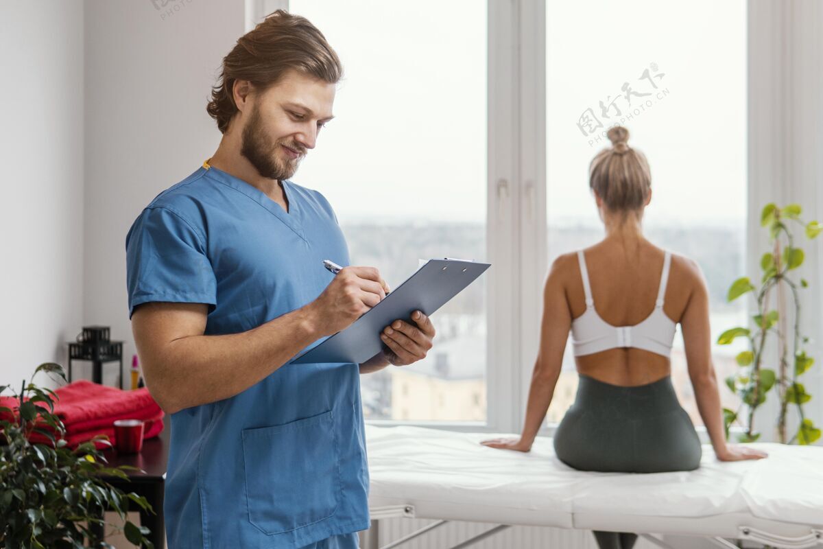 健康男骨科治疗师拿着剪贴板 女病人在办公室女人女人男人