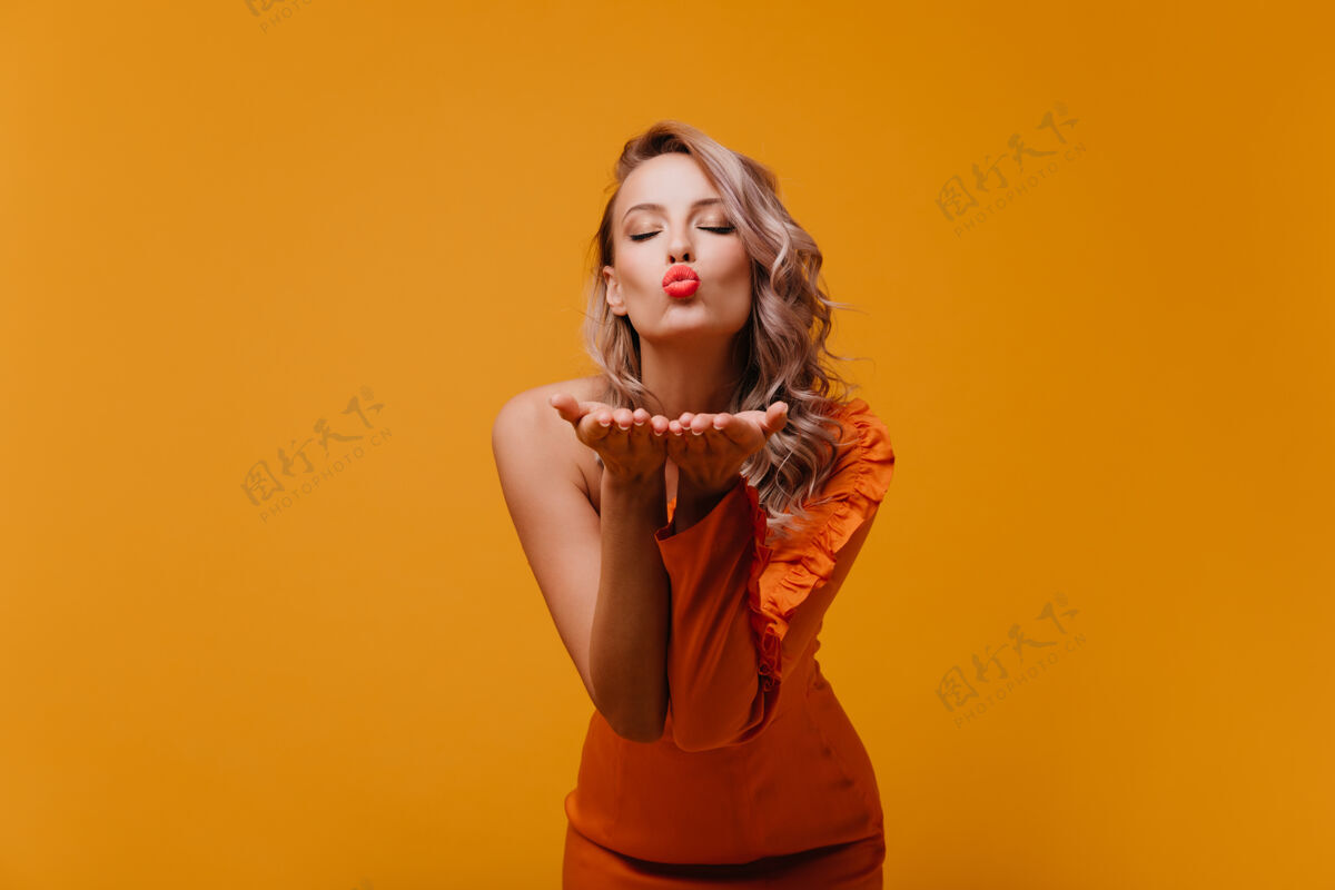 美丽快乐浪漫的女人穿着橙色的裙子表达爱女人女性服饰