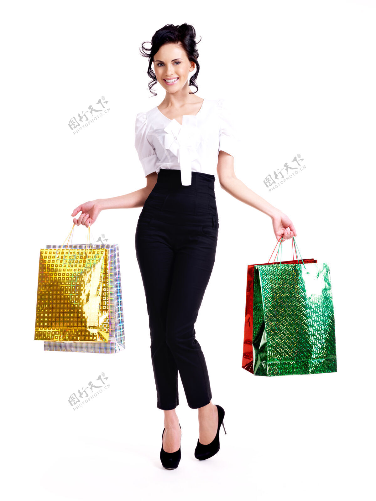 包幸福女人的全画像 带着彩色购物袋 孤立地站在白色的墙上购物购物者成人