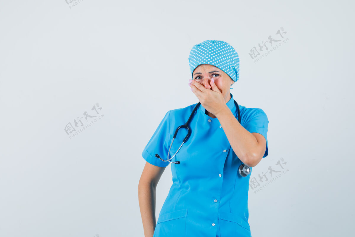 疾病女医生手放在嘴上 穿着蓝色制服 看上去很高兴正面图护士治疗病人