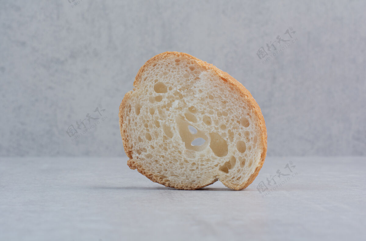 糕点在大理石背景上放一片新鲜的圆形白面包新鲜的面包片面包