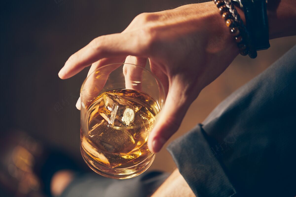 西装一个男人拿着一杯威士忌的高角度特写镜头问题酒精黑色