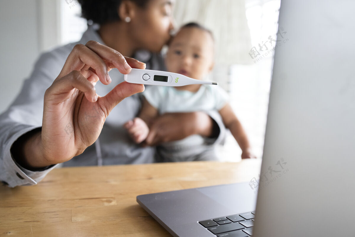 笔记本电脑非洲裔美国妈妈展示宝宝；通过远程医疗呼叫医生时事通讯感冒婴儿