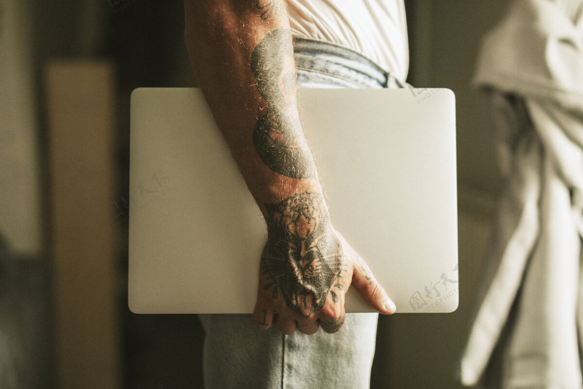 时事通讯带着笔记本电脑的纹身男人替代在线媒体