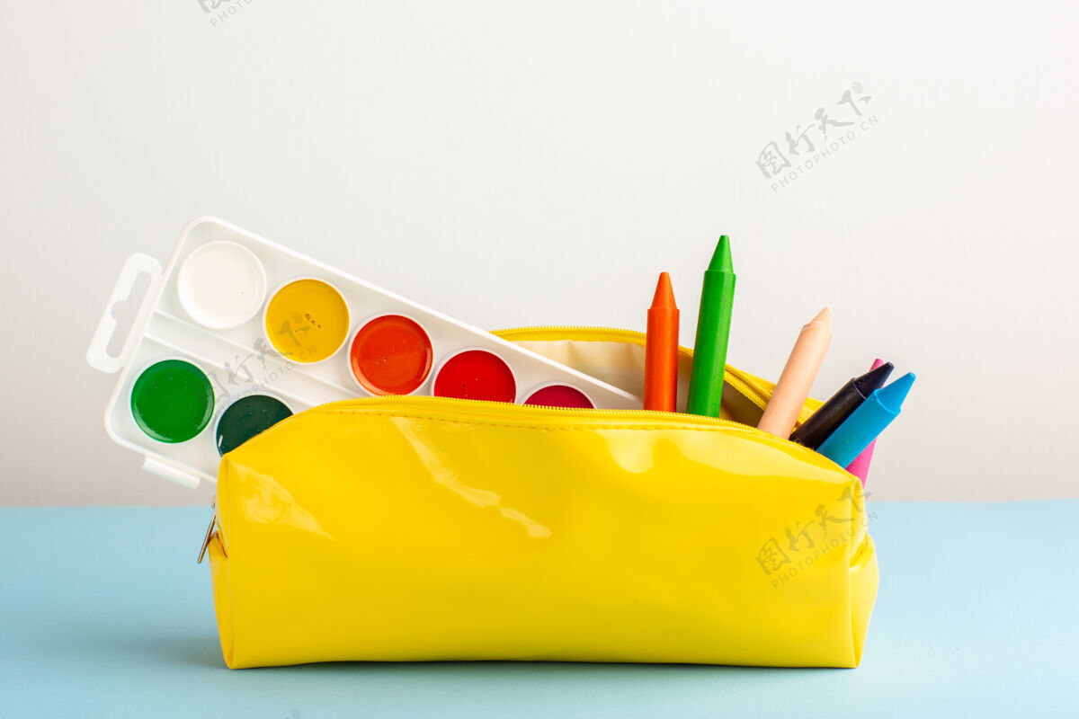 不同的前视图蓝色地板上黄色笔盒内不同颜色的铅笔记事本学校钢笔