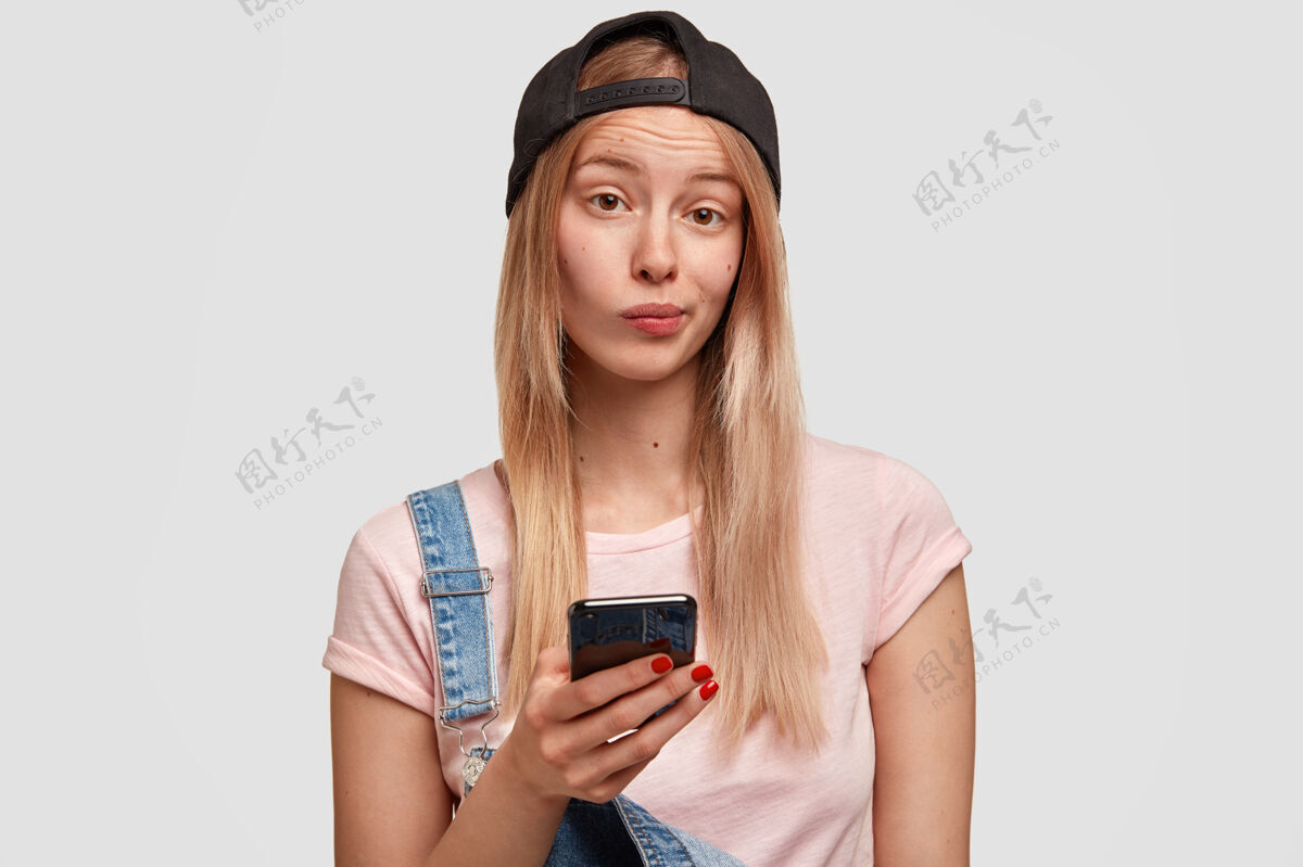 吸引力可爱时尚的女青年手持现代智能手机外观年轻人风格