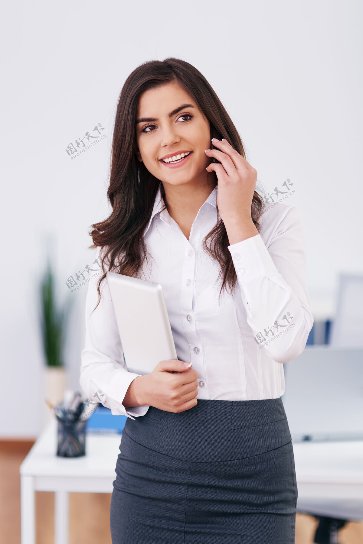 正装上班的女商人在办公室打来电话快乐室内快乐