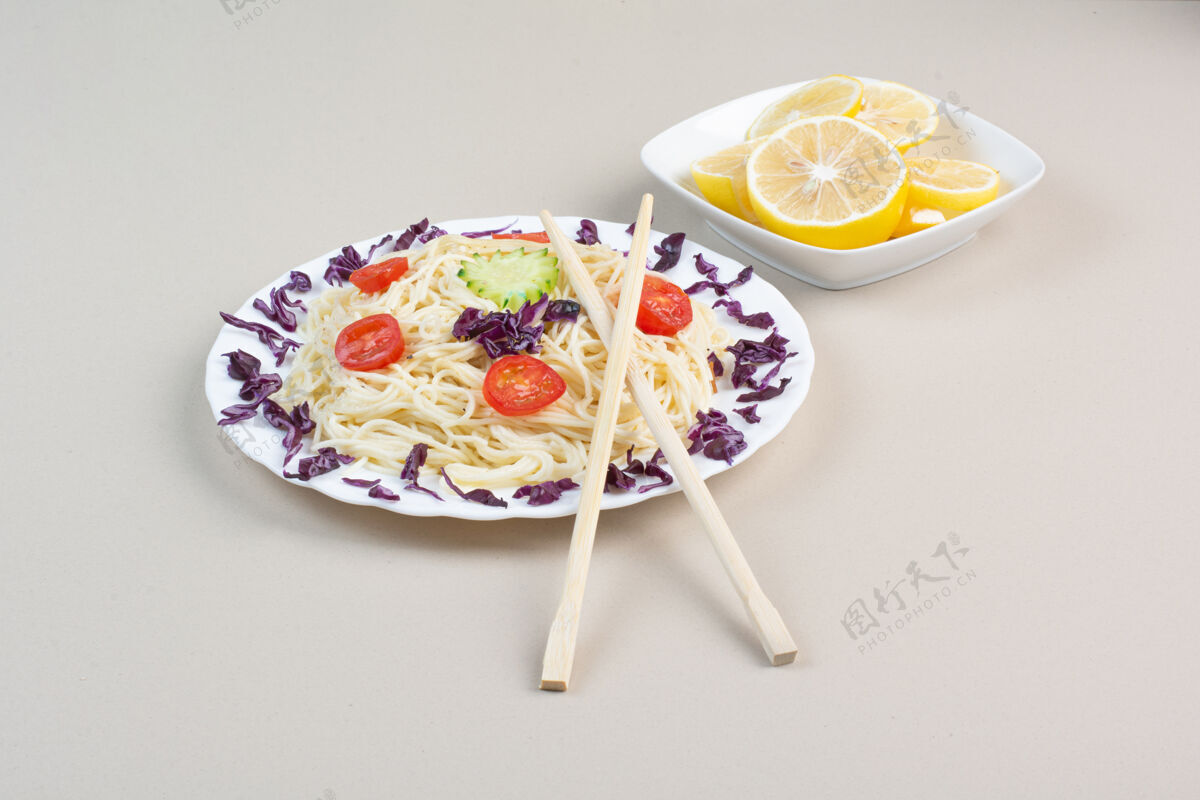 意大利面美味的意大利面和柠檬片在白色的表面自制晚餐食物