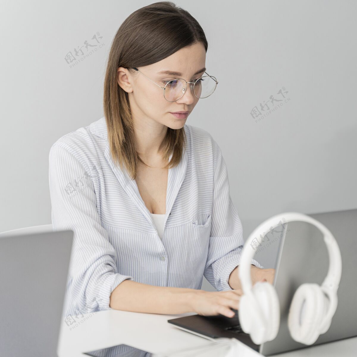灵感戴着耳机在笔记本电脑上工作的女人数据创意动力