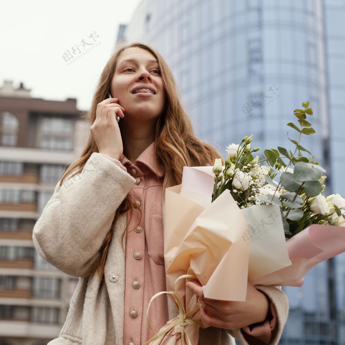 女性时髦的女人在户外打电话 手里拿着一束鲜花花季节安排