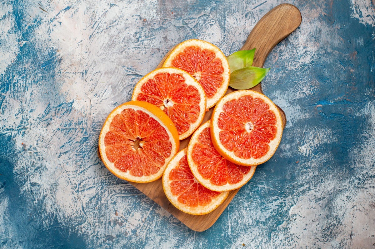 柑橘俯视图在蓝白表面的砧板上切柚子切割果汁水果