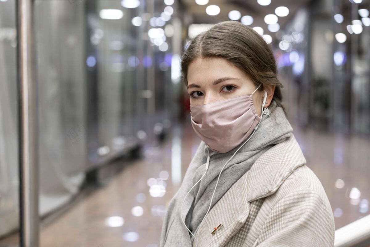 人类戴着医用口罩的女人在商场里新常态人大流行
