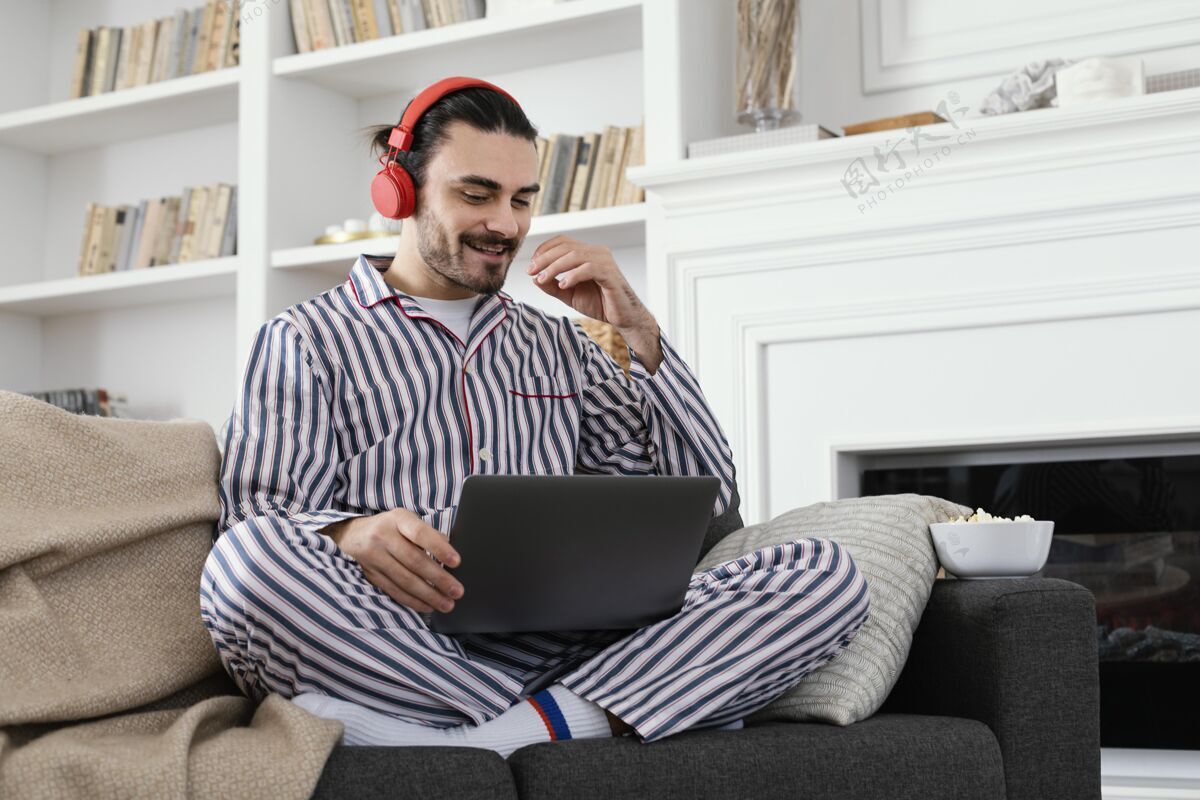 笔记本电脑穿着睡衣的男人在笔记本电脑上玩得很开心房子男人工作区