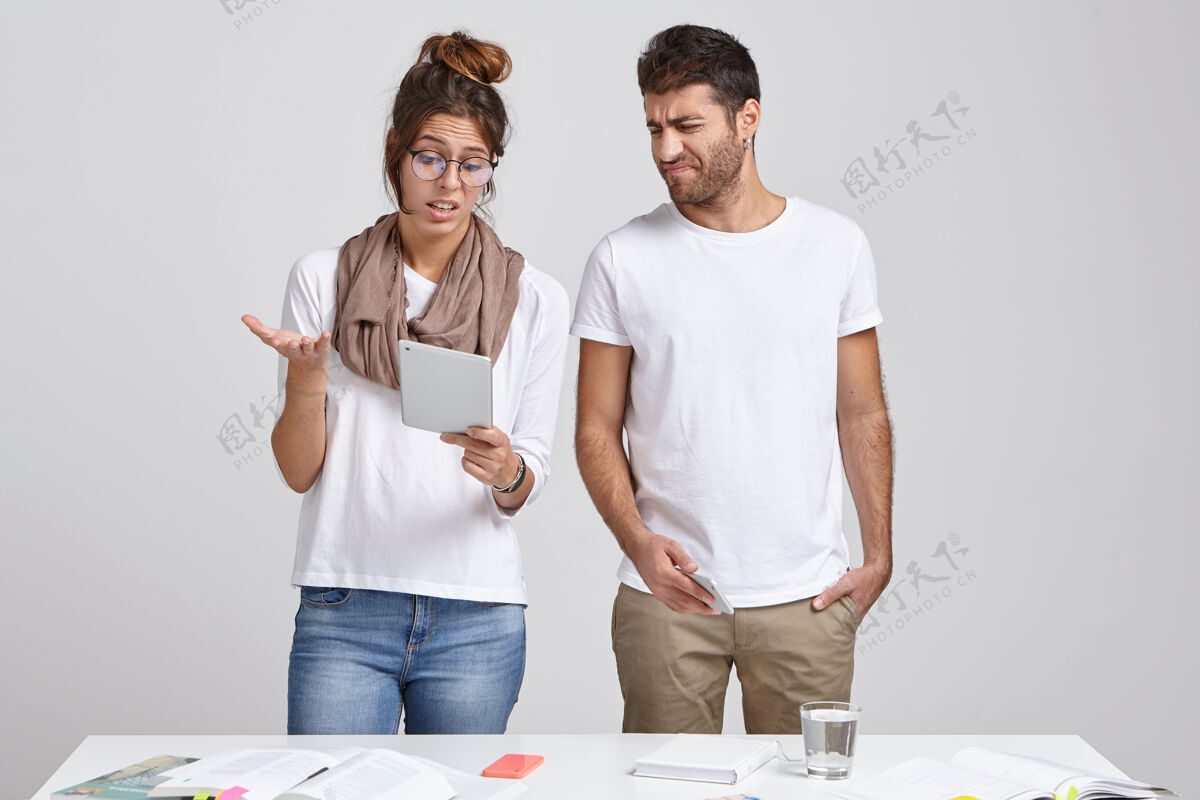设备年轻的妻子和丈夫一起站在办公桌旁桌子表情工作