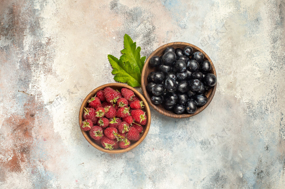 浆果顶视图树莓和葡萄碗在灰色孤立的表面与自由空间多汁草莓顶部