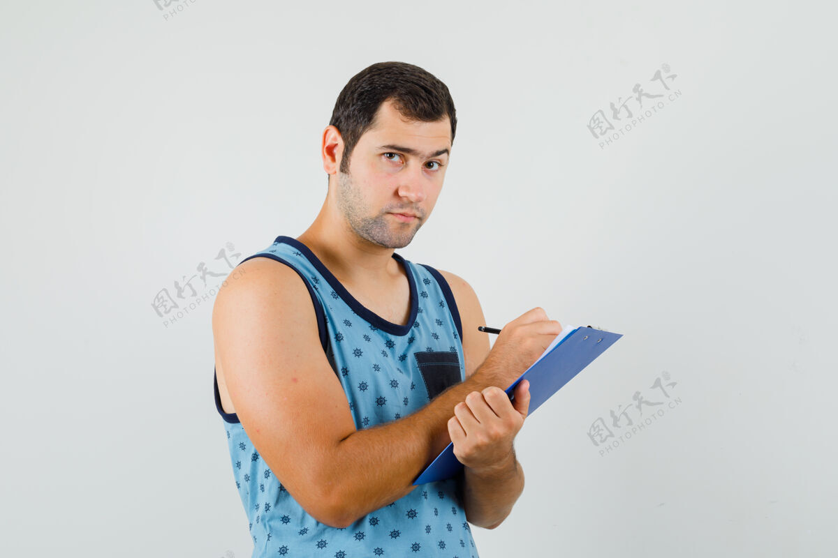 人年轻人在剪贴板上做笔记 穿着蓝色单品 面带沉思 正面照发型欢呼时尚