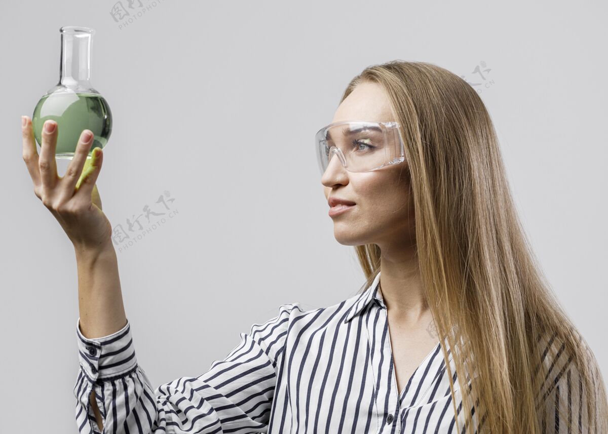 技术员戴着安全眼镜拿着试管的女科学家侧视图智力创新试管