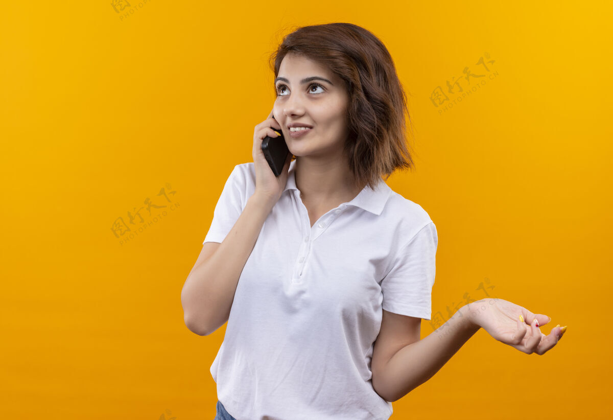 女孩穿着白色马球衫 留着短发的年轻女孩一边打电话一边微笑衬衫说话马球