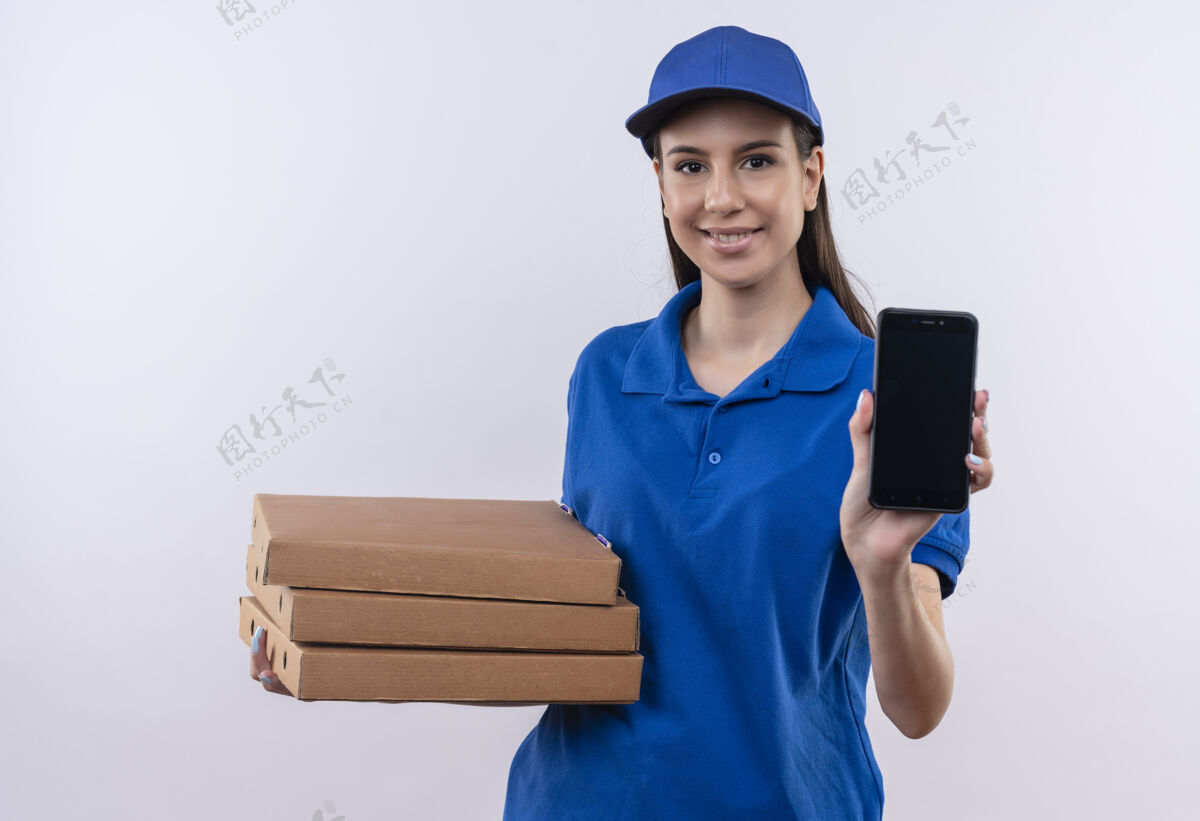 盒子身穿蓝色制服 戴着帽子的年轻送货女孩手里拿着一叠比萨饼盒 脸上露出自信的微笑披萨微笑自信