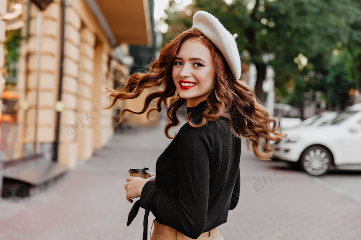 时尚优雅的长发姜黄色女孩回头看戴贝雷帽的美丽女人在享受散步城市街头风格茶