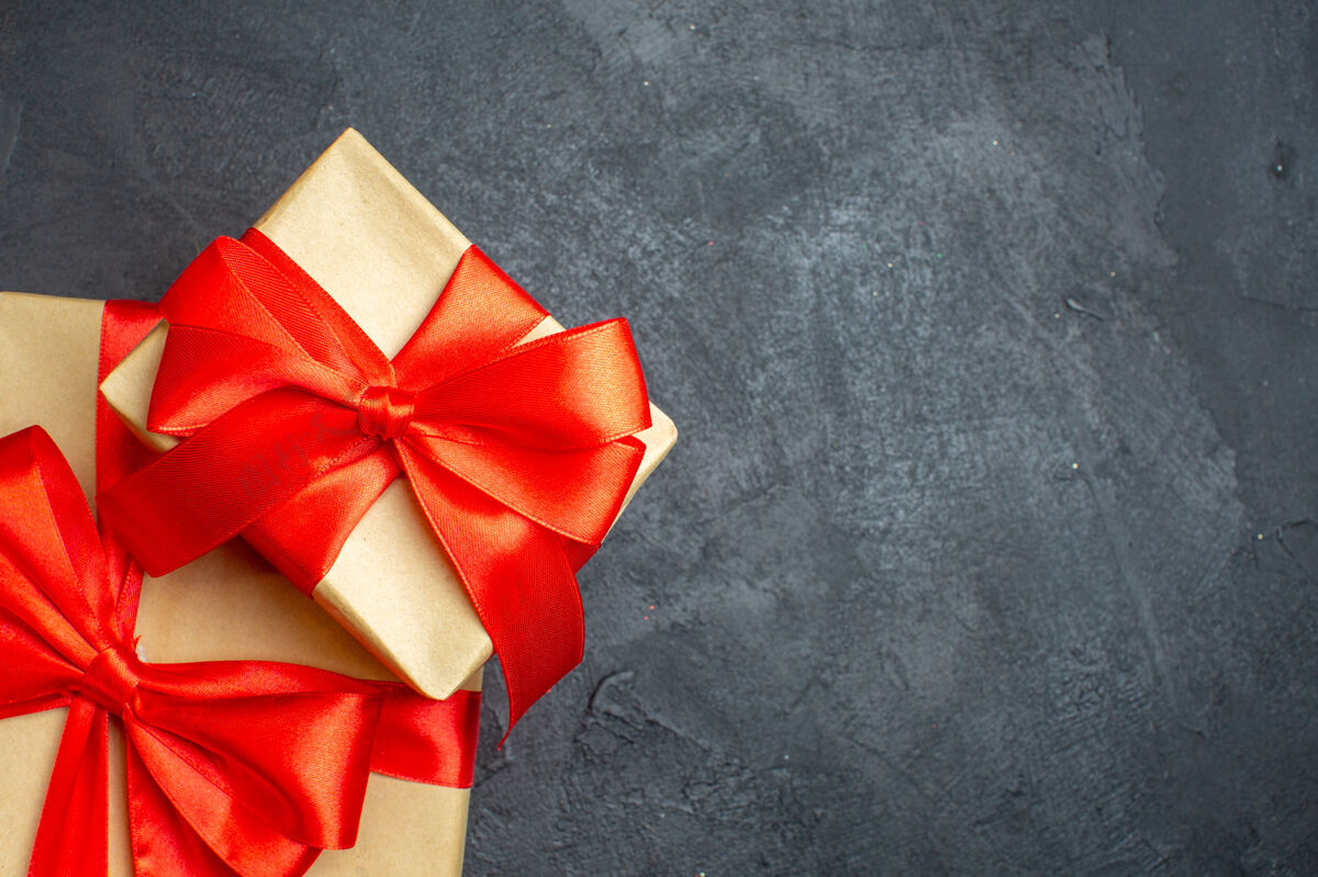 右边半拍的圣诞背景与美丽的礼物与蝴蝶结形丝带的右侧在一个黑暗的背景弓圣诞节轮子