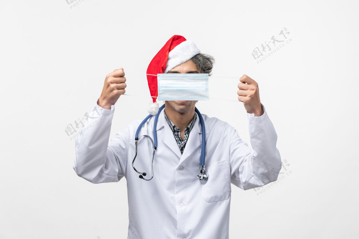 冠状病毒正面图男医生拿着口罩在白墙上过年护士实验室外套男人