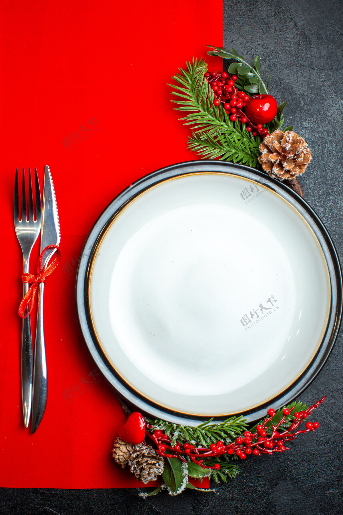厨房用具xsmas背景的垂直视图 带有餐盘装饰配件杉木树枝和餐具放在红色餐巾上碗热的观点
