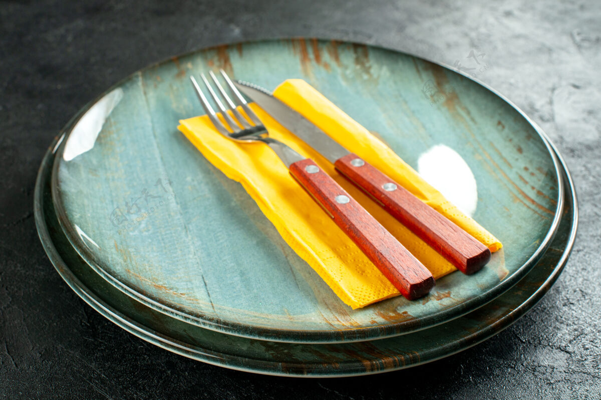 刀片下图黄色餐巾纸刀叉放在黑色桌子上的圆板上餐巾纸学校圆板