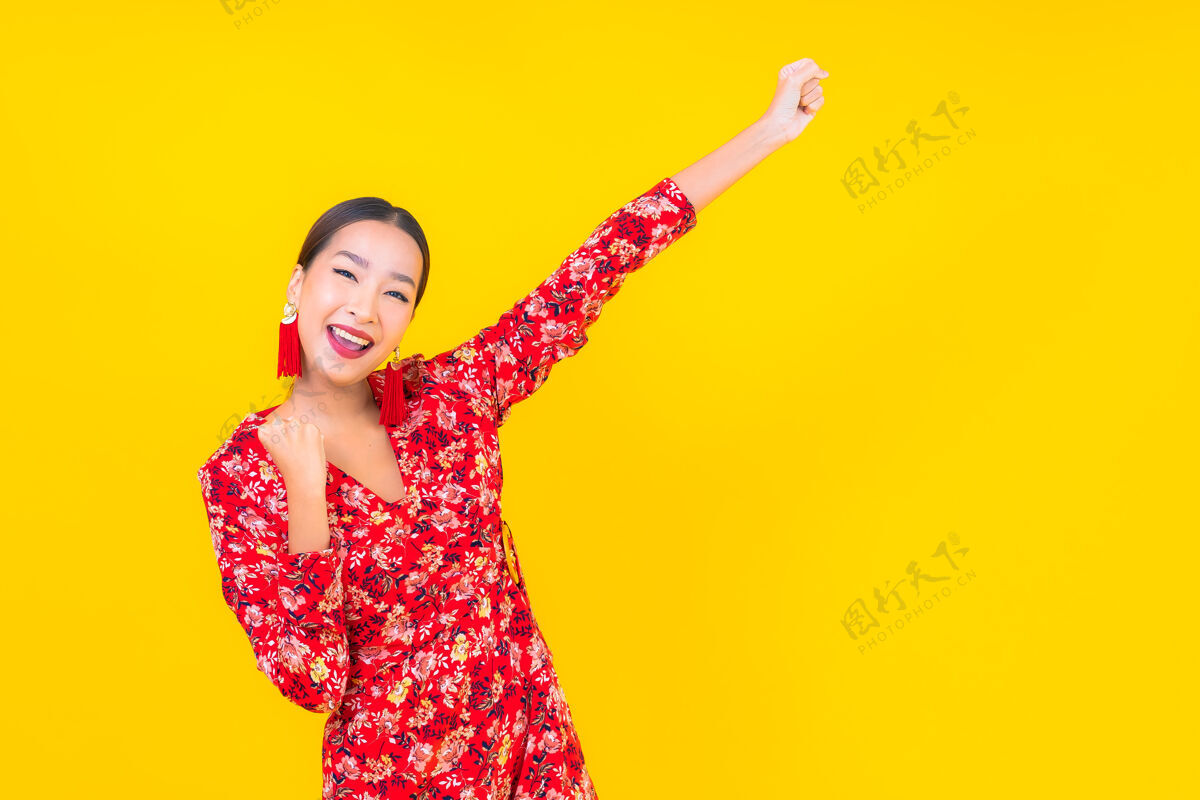 人美丽的亚洲年轻女子在彩色墙上的中国新年概念中的微笑女士金融观点
