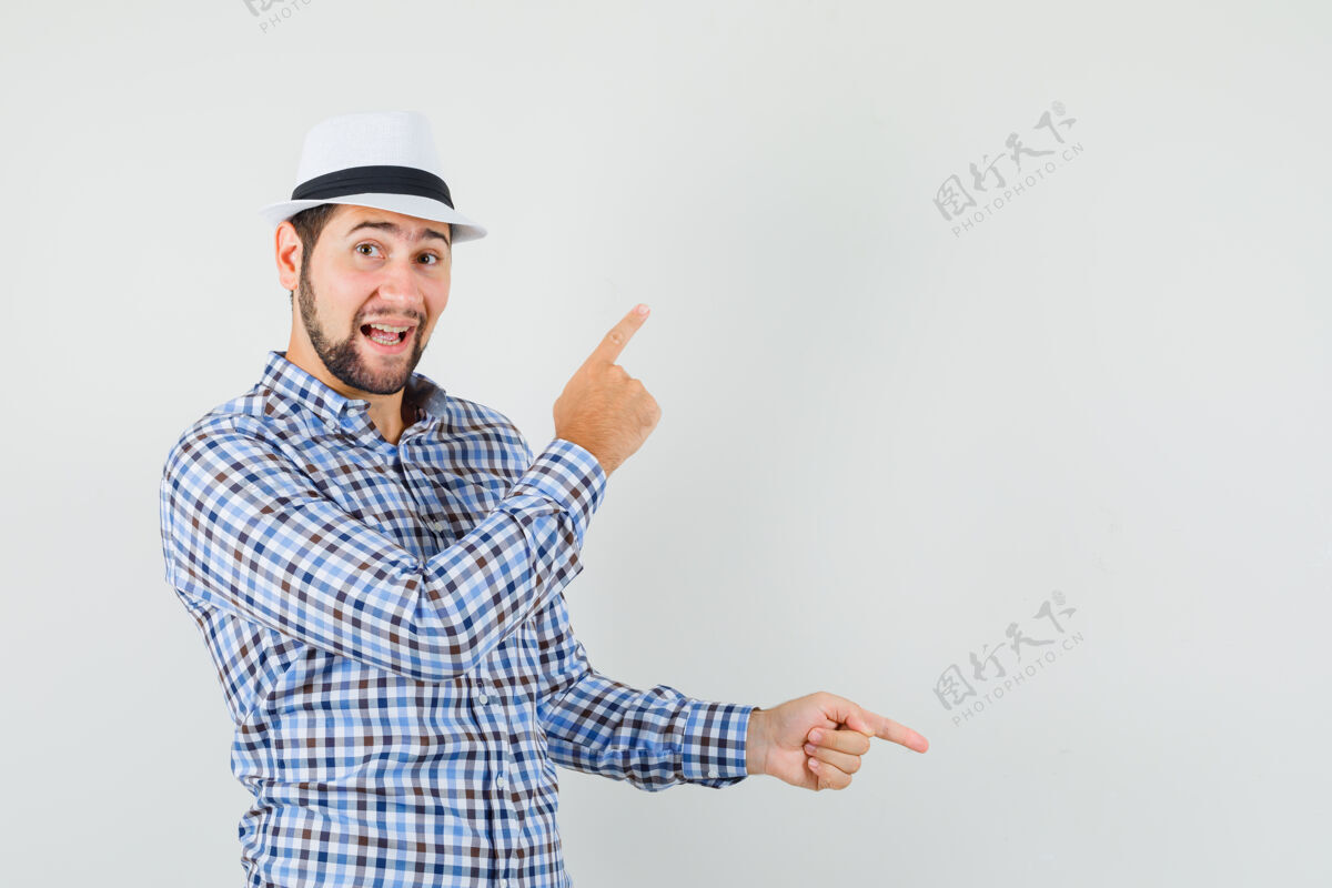 自信一个穿着格子衬衫 戴着帽子的年轻人 手指上下摆动 看上去很快乐 从正面看去男人手指休闲