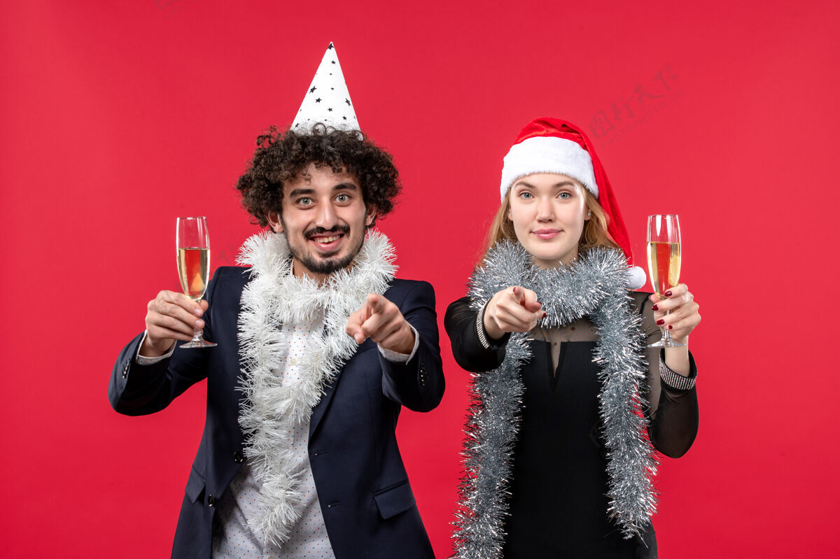 庆祝前视图年轻夫妇刚刚庆祝新年红墙爱圣诞晚会服装新年成人