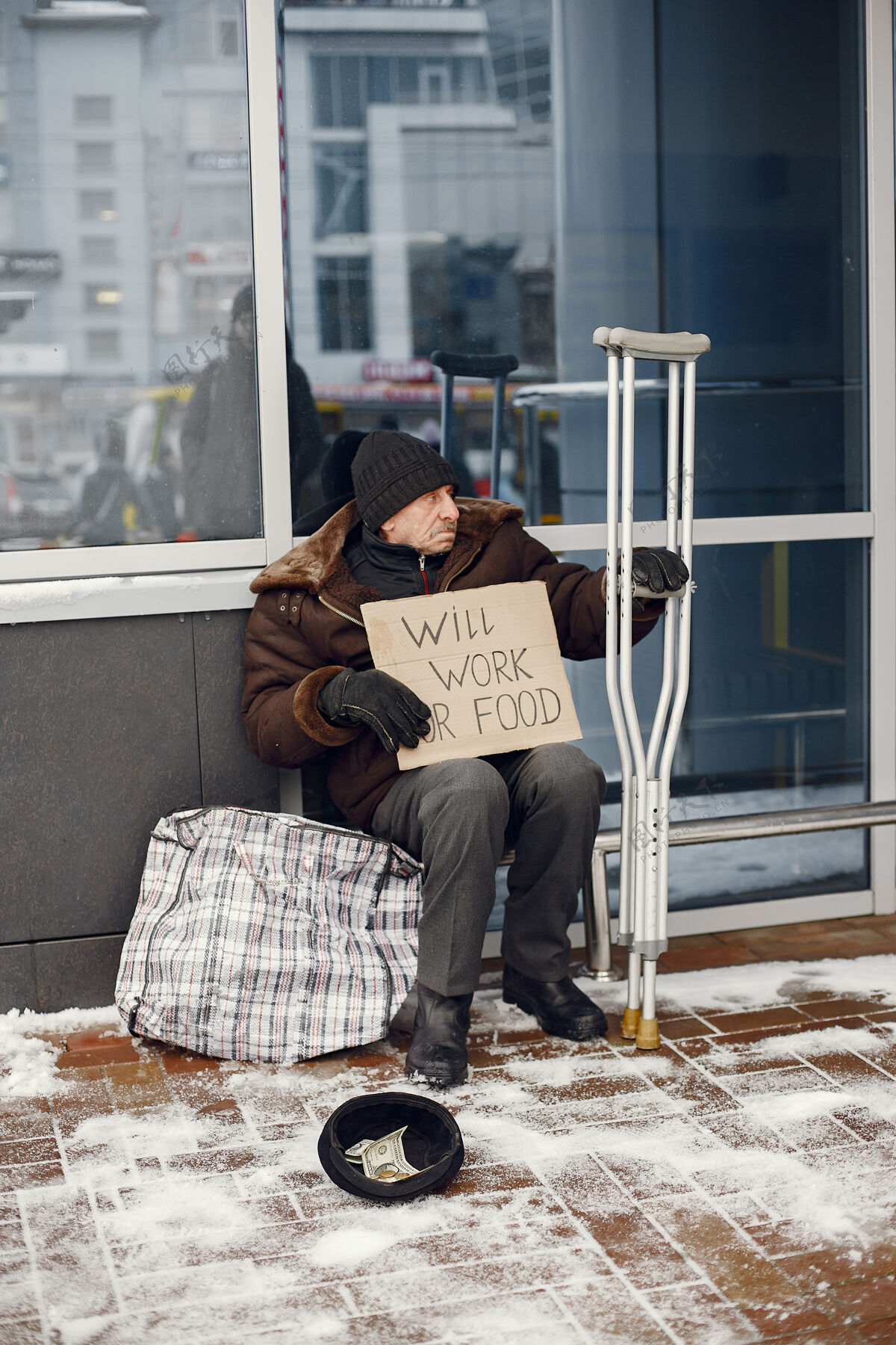 户外无家可归的人坐在大楼附近纸板坐着男人