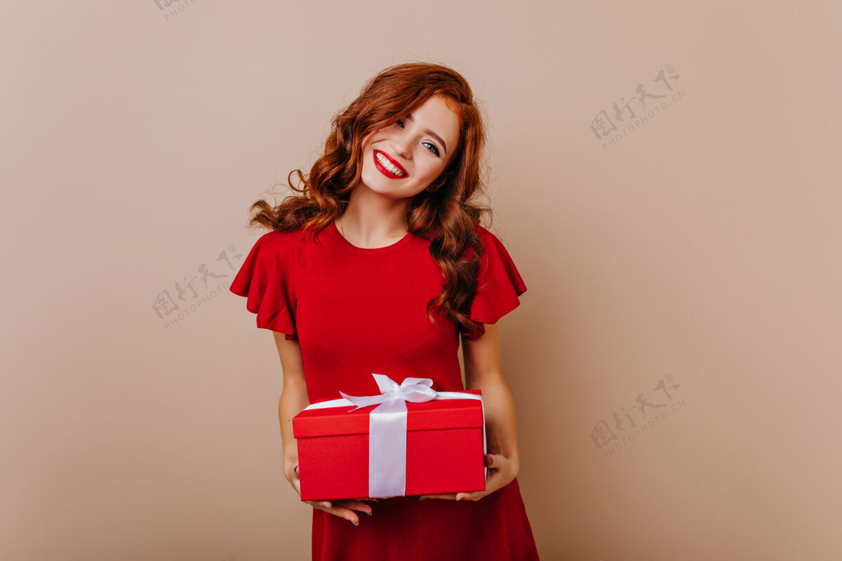 红发红发生日女孩微笑着可爱的红衣女模特手持圣诞礼物惊喜女人节日