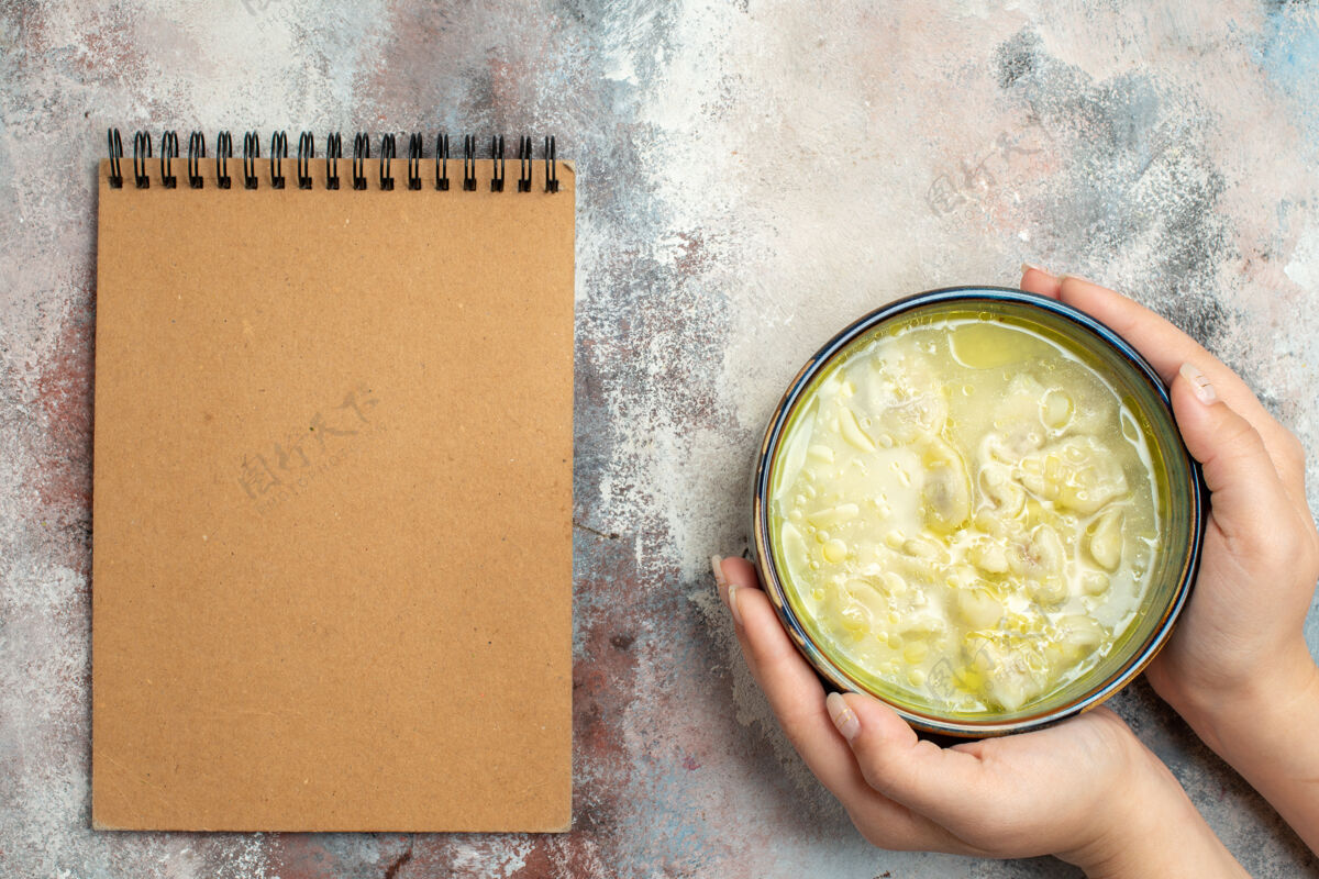 烹饪俯瞰杜什巴拉汤圆汤碗中的女性手一本笔记本上的裸体表面杜什巴拉饺子汤观点晚餐