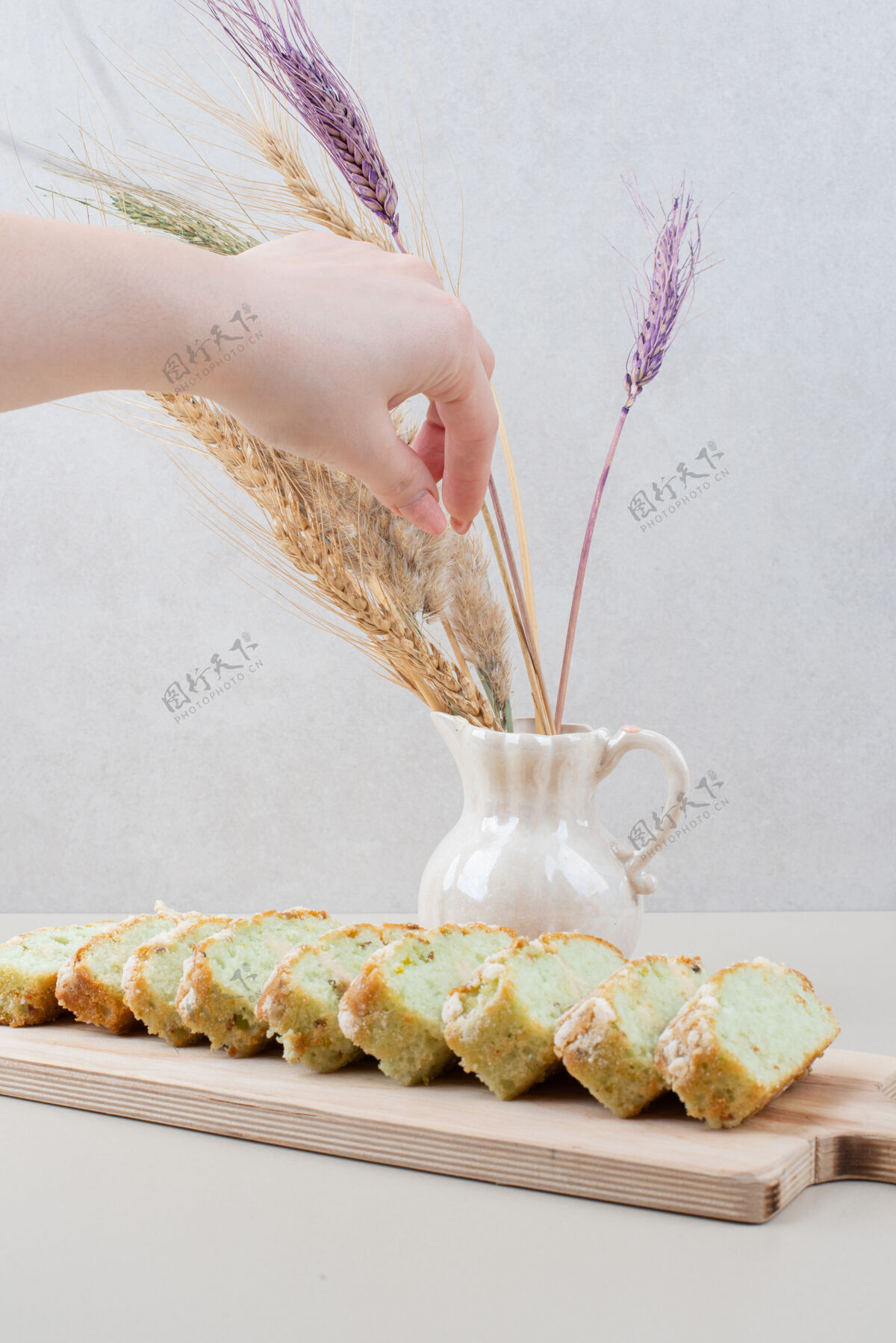 吃一杯茶和开心果蛋糕片放在白色的表面上玻璃茶木板