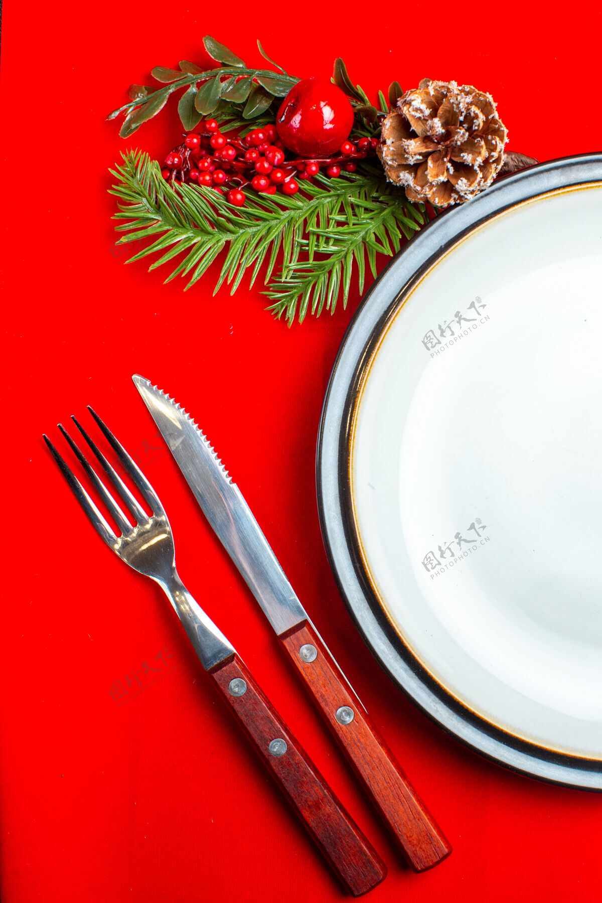 视图垂直视图的空板和冷杉枝装饰配件针叶树锥上的红色餐巾和餐具设置在一个黑暗的背景采购产品圣诞节冷杉油漆刷