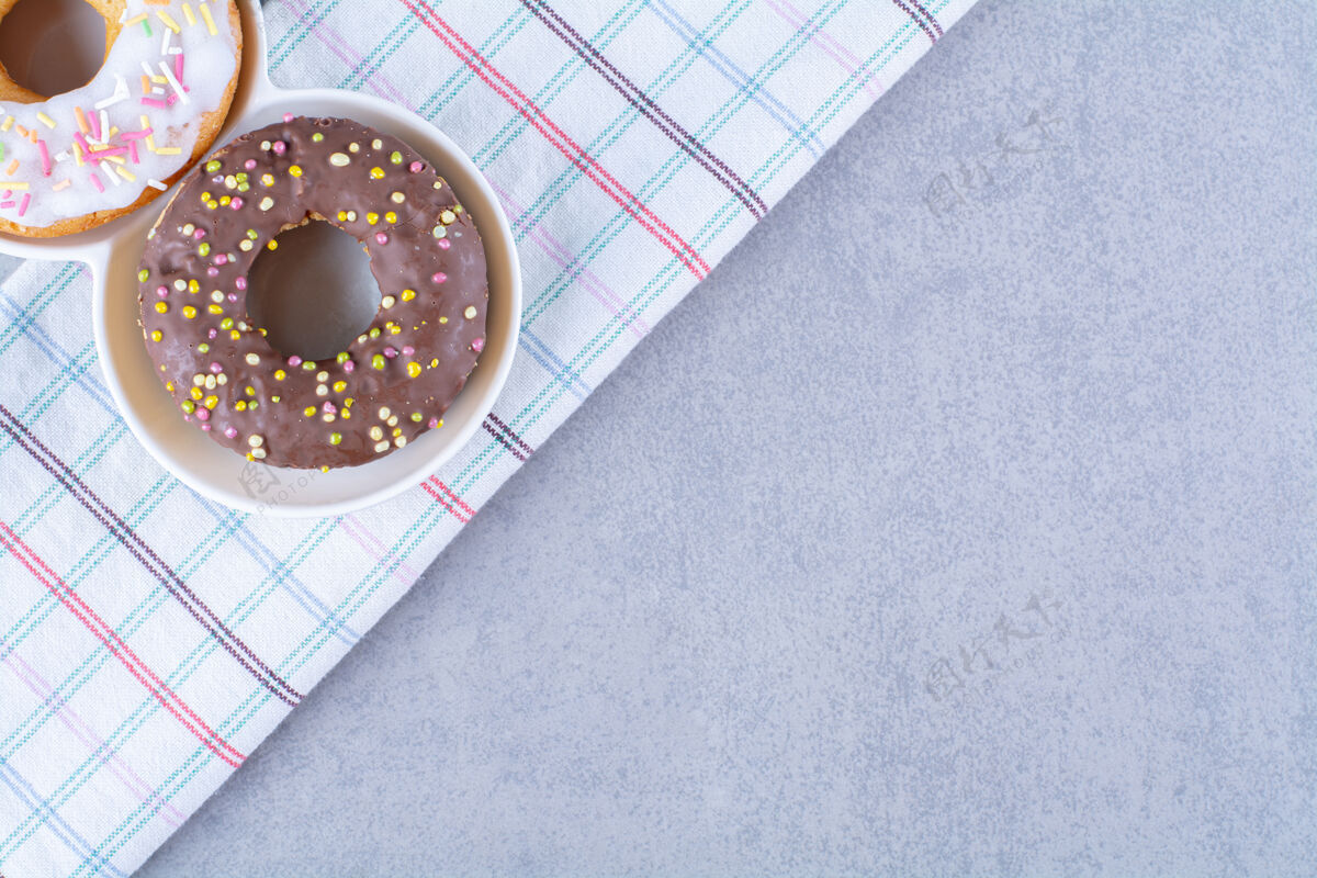 甜食在桌布上撒上五颜六色的巧克力甜甜圈巧克力食物桌布