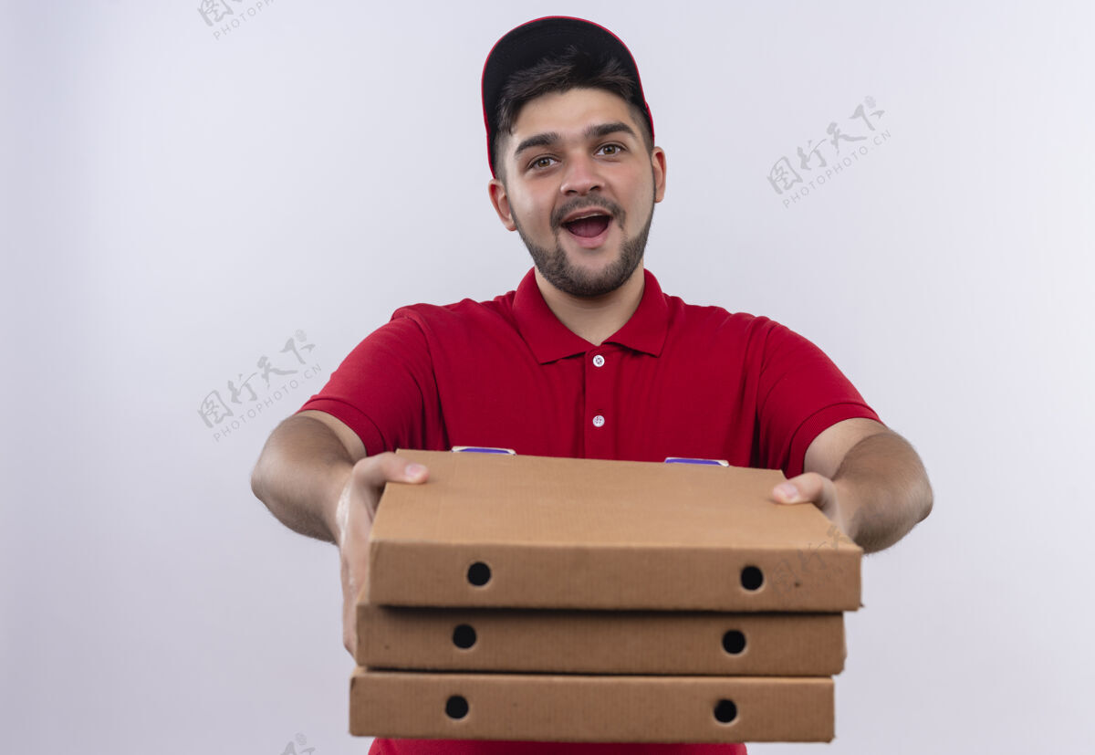 制服年轻的送货员身穿红色制服 头戴鸭舌帽 手里拿着一叠披萨盒 脸上洋溢着自信的笑容送货盒子拿着