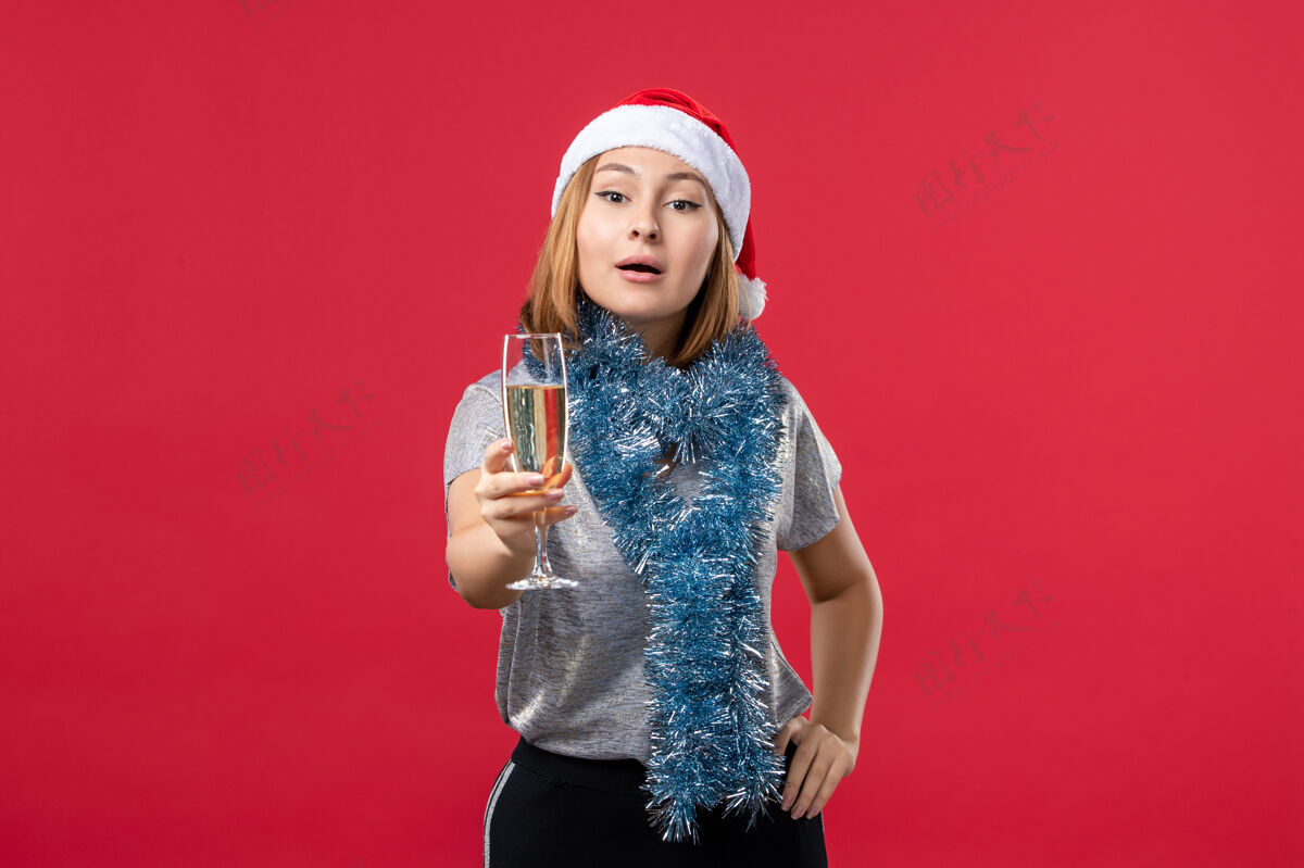 色彩正面图年轻女性在红墙彩圣诞假期庆祝新年庆祝成人姿势