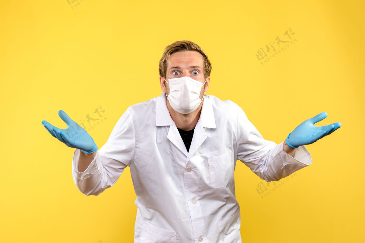 冠状病毒正面图黄色背景上的男医生惊讶大流行的柯维德健康医生惊喜商人正面
