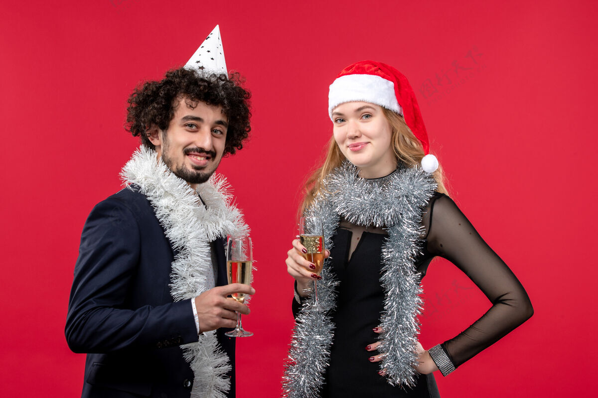 服装正面图年轻夫妇在红墙庆祝新年节日圣诞之爱圣诞节年轻夫妇美丽