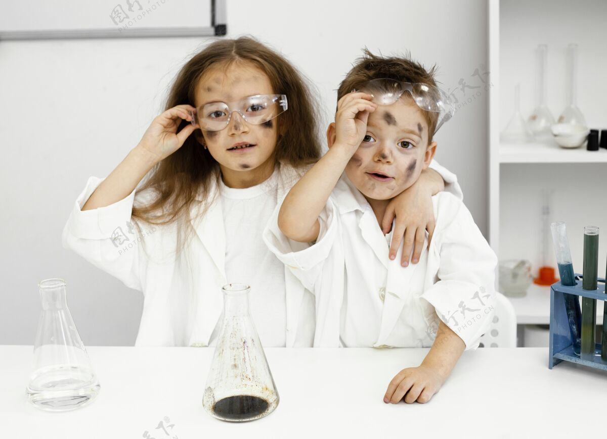 学习可爱的女孩和男孩科学家在实验室里用试管和失败的实验安全眼镜青年学习